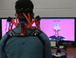 A healthy subject reaching to a desired head-neck posture, displayed via avatars, while wearing the neck brace.